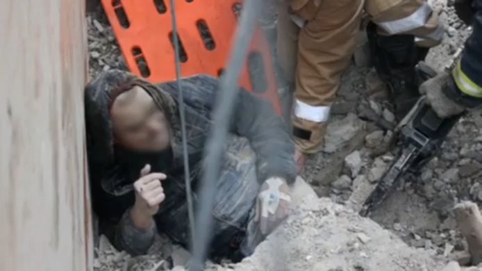 Hulpdiensten halen een man van onder het puin in Charkiv.