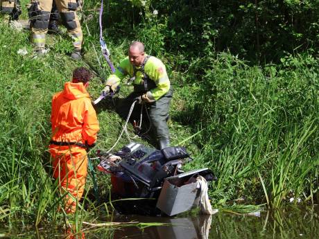 Man rijdt met rolstoel water in Veghel in, omstander springt water in om hulp te bieden 