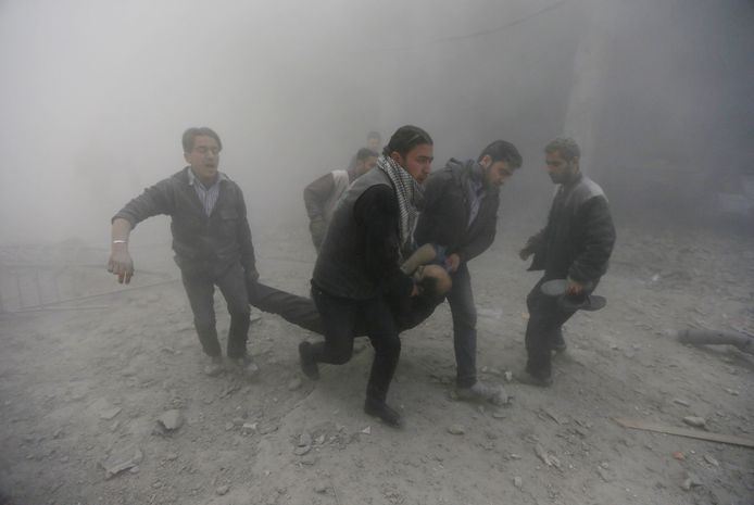 Bewoners van Douma dragen een gewonde man na een luchtaanval.