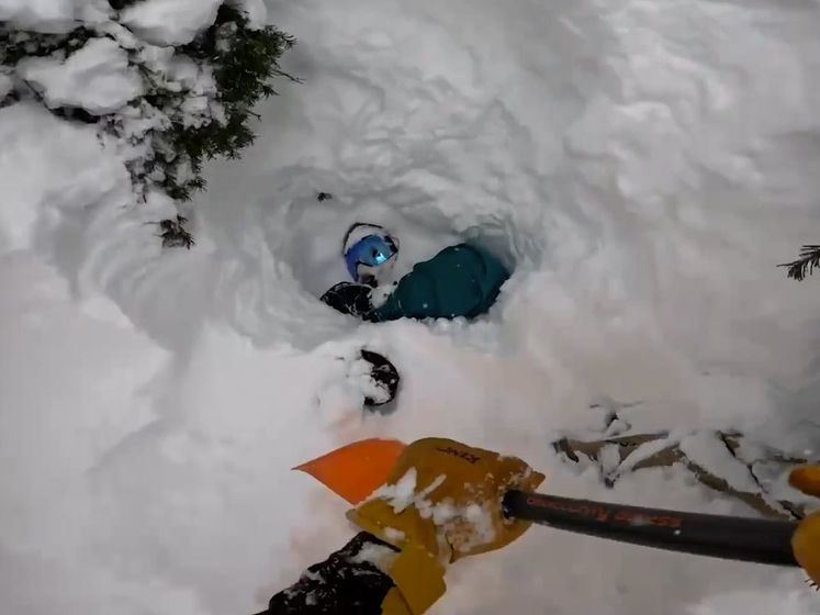 Amerikaanse skiër graaft onder sneeuw bedolven snowboarder uit