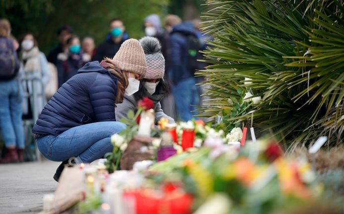 Mensen komen bloemen, kaartjes en kaarsen neerleggen voor de slachtoffers.