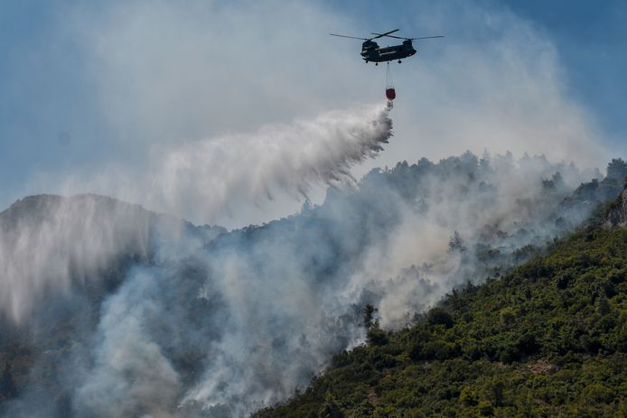 Een Chinook-helikopter dropt water op een bosbrand in de buurt van Malakasa, ten noorden van Athene.