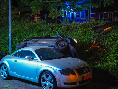 Roekeloze bestuurder neemt stroomkast, fiets en hek mee en botst bovenop geparkeerde auto