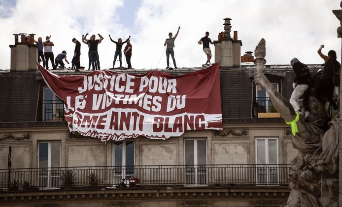 Extreemrechtse tegenbetogers lieten een spandoek met het opschrift “rechtvaardigheid voor de slachtoffers van anti-wit-racisme” van een gebouw zakken.