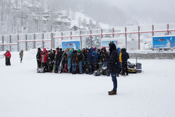 Wintersporters staan in de rij te wachten op een vlucht met de helikopter naar Täsch.