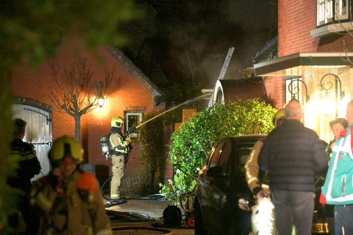 De brandweer blust de brand in de woning.
