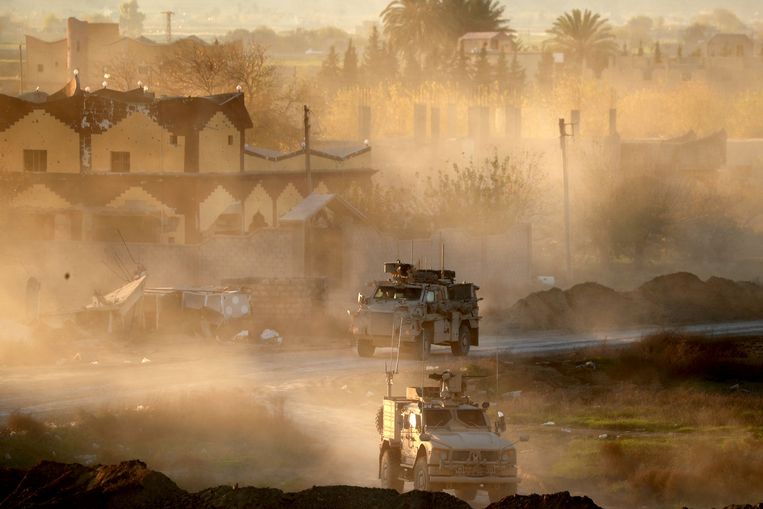 Amerikaanse militaire voertuigen patrouilleren in Hajin in Oost-Syrië. De stad geldt als een van de laatste bolwerken van IS. Beeld AFP