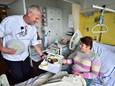 Souschef Marc Persoon biedt patiënt Anita Zwijnenburg in het Groene Hart Ziekenhuis haar vegetarische maaltijd aan.
