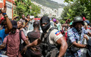 Des policiers et des personnes dans la rue à Haïti au commissariat de police où sont détenus les suspects de l'assassinat du président.