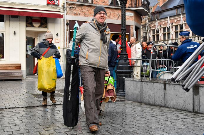 Gepakt en gezakt verlaten wachtenden de rij om de Grote Markt op te komen en hun polsbandje te krijgen.