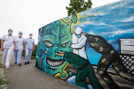 Een graffiti-artiest creëerde dit kunstwerk waarin artsen en verplegers strijd leveren tegen het coronavirus. Het werk staat aan de ingang van een ziekenhuis in Mulhouse, een van de zwaarst getroffen steden.