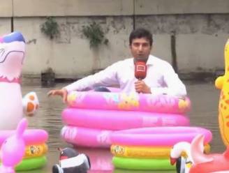 Reporter doet verslag van overstroomde stad vanuit roze kinderbadje
