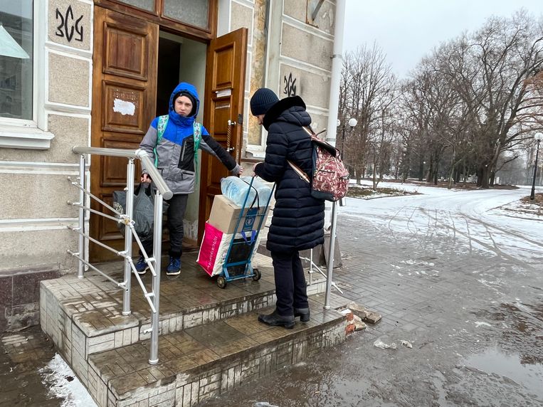 Natalia Dennyk en haar zoon Dima halen een hulppakket op bij de humanitaire post in de stad. Beeld Michiel Driebergen