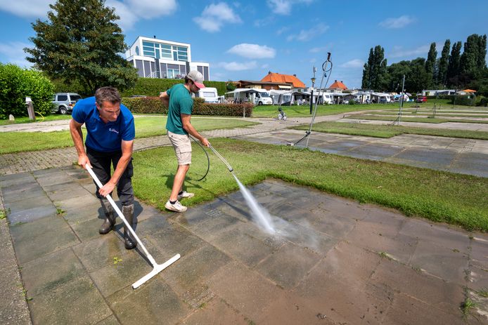 Op Camping Waalstrand in Gendt zijn vader en zoon Cornelissen al begonnen met het schoonmaken van de eerste drooggevallen plaatsen.