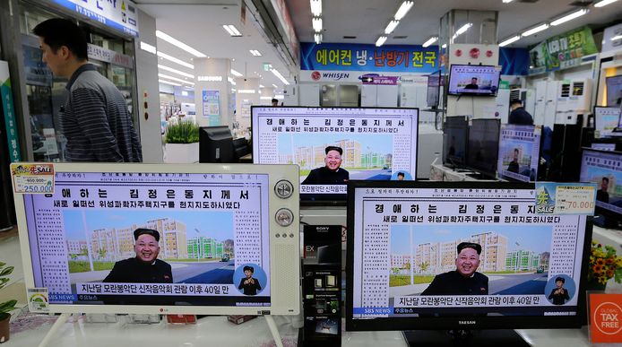 Foto's van Kim Jong-un op beeldschermen in een elektronicawinkel in Noord-Korea.