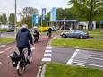 Fietsers, brommerrijders en automobilisten in de ochtendpits op de rotonde van de Pieter Calandweg.