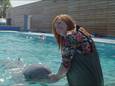 Een bezoeker van het Dolfinarium poseert voor een foto met een dolfijn. Dit beeld is afkomstig uit een promotievideo van het park.