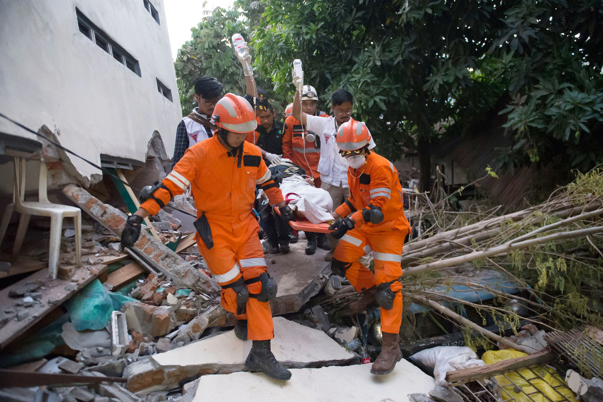 Reddingswerkers evacueren een gewonde overlevende van de aardbeving en tsunami die het Indonesische eiland Sulawesi vrijdag troffen. Beeld AFP