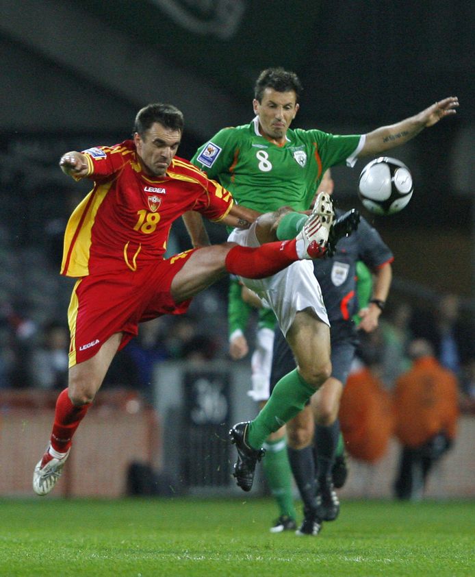 Liam Miller (r) namens Ierland in duel met de Montenegrijn Nikola Drincic op 14 oktober 2009.