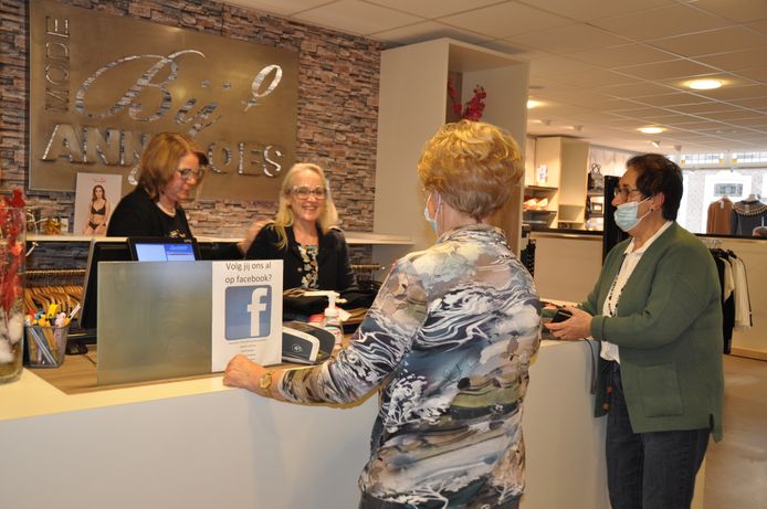Anneloes van de Mosselaar (achter kassa rechts) en Diny Haakmeester helpen klanten in de winkel in Waspik. Rechts op de foto mevrouw Barendse.