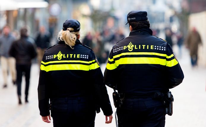 Politieagenten surveilleren in een winkelstraat.