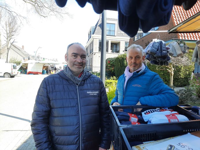 Marktkooplieden Richard Denkers (l) en Jan Lubbers bij de 'illegale sokkenkraam' op de markt in Voorthuizen. Op de achtergrond de gewone warenmarkt op zaterdagochtend.