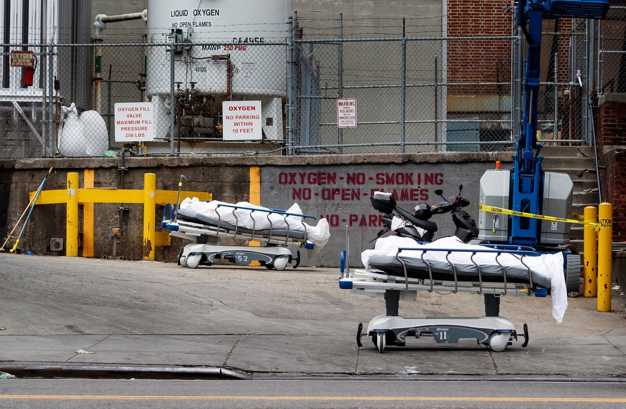 Twee overleden patiënten staan geparkeerd achter een ziekenhuis in Brooklyn. Beeld EPA