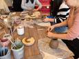 Een aantal deelnemers aan de workshop zijn druk in de weer met de kannetjes.