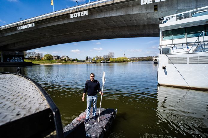 Stuurman Marko Rakuljic uit Kroatië toont op de kop van de boot van ‘Constant in Beweging’ de plek waar hij op donderdagavond naar de drenkeling peddelde onder de Nelson Mandelabrug in Arnhem. Op de achtergrond het motorpassagiersschip De Zonnebloem.