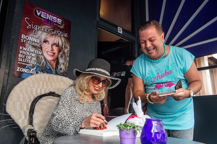 Zangeres Bonnie St. Claire (71) signeert haar biografie 'kwam een vrouw bij de slijterij' op het terras van de Venise Bar in de halstraat.