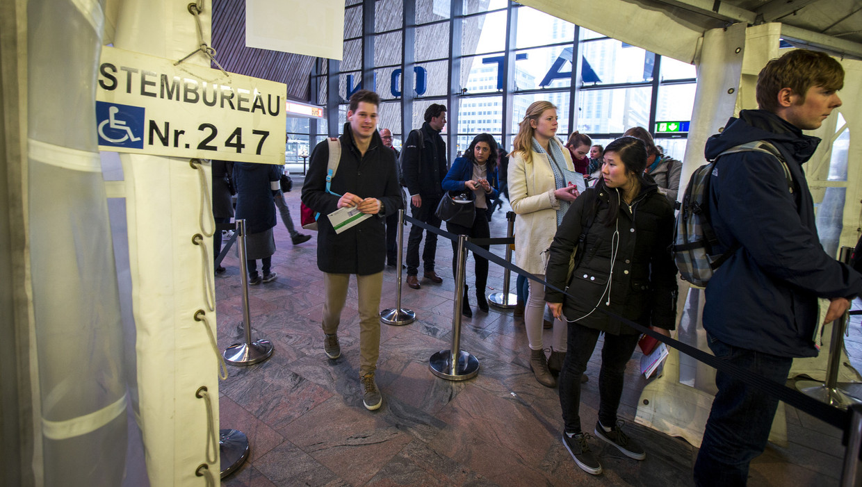Reizigers brengen hun stem uit voor de Provinciale Statenverkiezingen op station Rotterdam Centraal. Beeld anp
