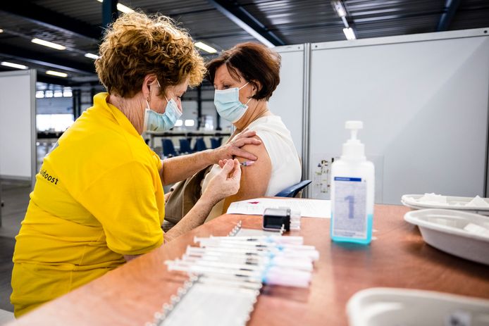 Een medewerker van de GGD Brabant-Zuidoost zet een boosterprik bij de vaccinatielocatie in Helmond.