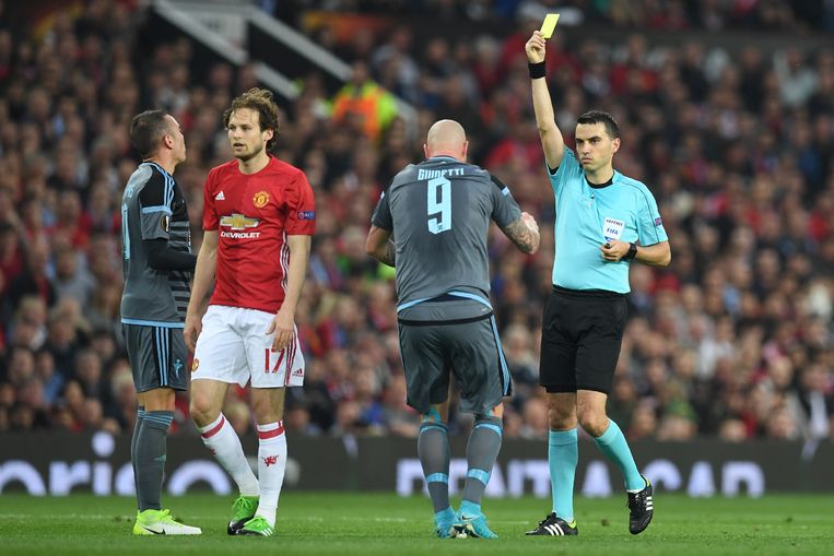 Daley Blind, toen nog in dienst van Manchester United, krijgt een gele kaart van de Roemeense scheidsrechter Ovidiu Hategan. Beeld Hollandse Hoogte / AFP