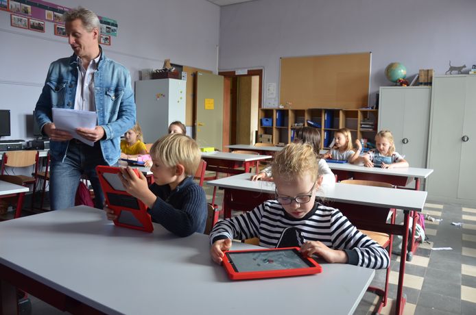 De kinderen gaan aan de slag met een tablet.