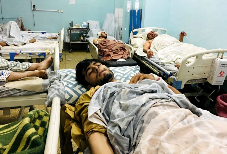 Gewonde Afghanen liggen op een bed in een ziekenhuis na dodelijke explosies buiten de luchthaven in Kaboel, Afghanistan, donderdag 26 augustus 2021.  Beeld AP