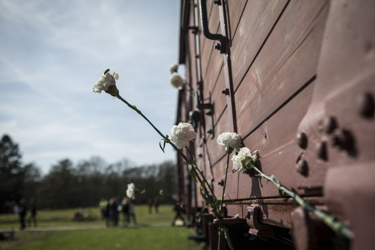 Ter nagedachtenis zijn bloemen bevestigd aan de goederenwagons bij Kamp Westerbork. Beeld anp