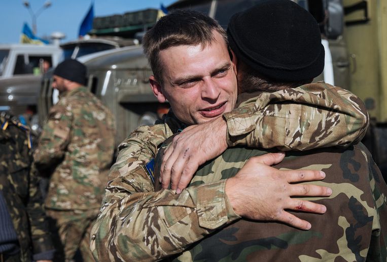 Oekraïense soldaten nemen afscheid van elkaar na een bewogen periode in het oosten van Oekraïne. Beeld anp