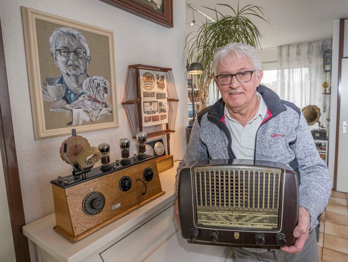 Verzamelaar Tom Rentmeester met in zijn handen een Philips radio uit 1950. Op de schouw een door hem nagebouwde Van der Meer-radio uit de jaren ‘20. Daarbij  staat ook een ‘raamantenne'.