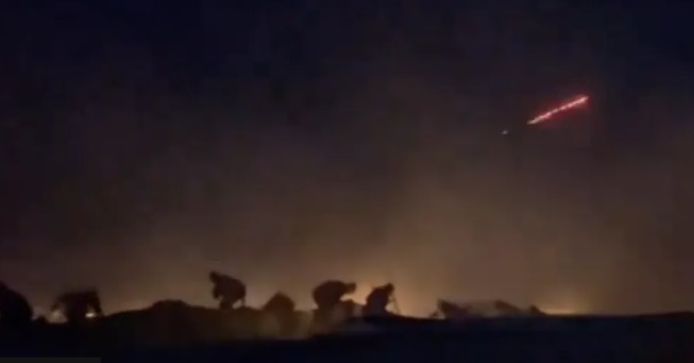 Een afbeelding uit een Al Jazeera-video, dicht bij de achterkant van het konvooi gefilmd, toont mensen die zich verstoppen achter voertuigen. Er is ook een rode lichtflits te zien.