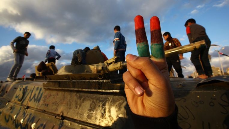 Boven en onder: kinderen spelen met aan troepen van Kadhafi buitgemaakte pantservoertuigen buiten Benghazi. Beeld epa