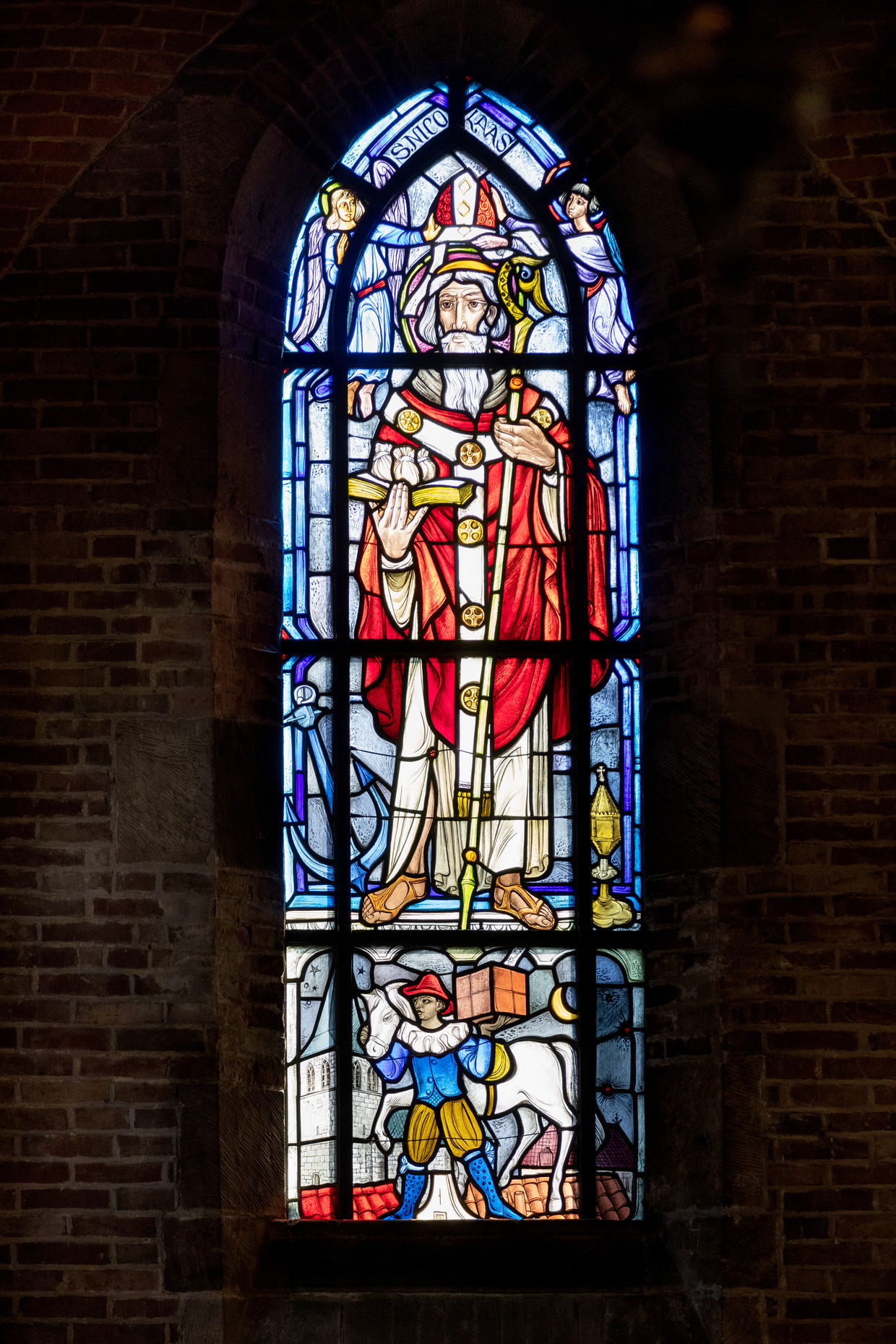 In de Sint Nicolaaskerk in Denekamp staat op een glas in loodraam, Zwarte Piet afgebeeld.   Beeld Herman Engbers
