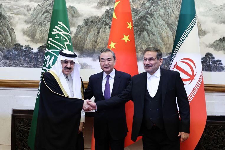 De Chinese topdiplomaat Wang Yi vrijdag in Peking tussen de Saudische nationale veiligheidsadviseur Musaad bin Mohammed Al Aiban (links) en Ali Shamkhani, secretaris van de Iraanse Nationale Veiligheidsraad.  Beeld Reuters