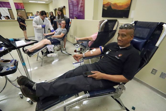 Carlos Flores (voorgrond) doneert bloed in de bloedbank van United Blood Services in El Paso.