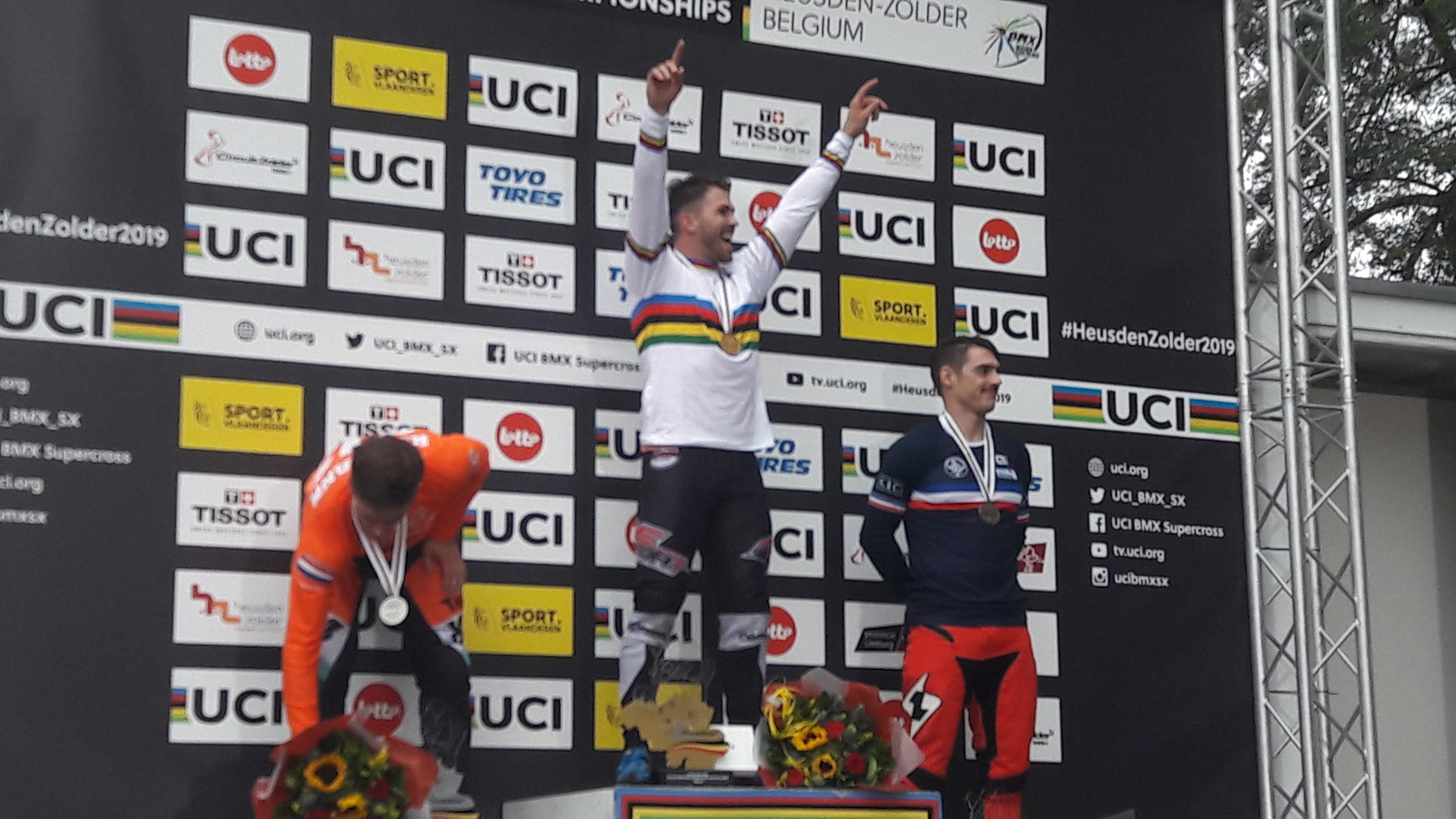 Twan van Gendt wil op het podium in Zolder weten dat hij wereldkampioen is. Links nummer twee Niek Kimmann. Rechts bronzen Sylvain Andre uit Frankrijk.