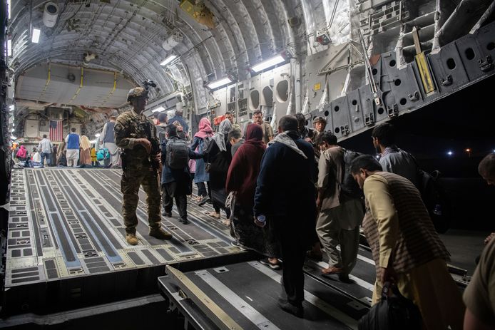 Afghaanse evacués gaan op het vliegveld van Kaboel aan boord van een Amerikaans vliegtuig.