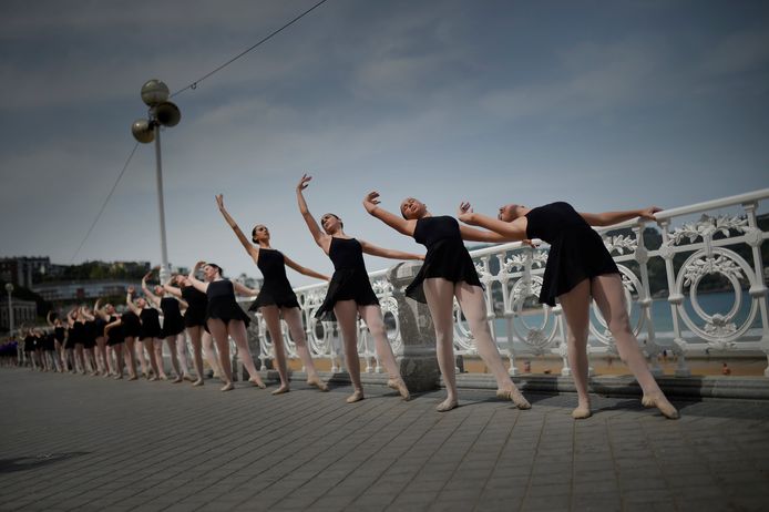 Spaanse balletdansers doen een warming up aan de barre, buiten op de boulevard, langs de Concha baai in San Sebastian. Foto Vincent West