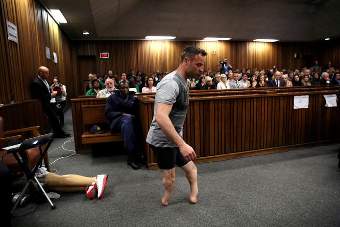 Op de derde dag van zijn proces, in juni 2016, gespt Pistorius zijn protheses los. Hij stapt door de rechtszaal.
