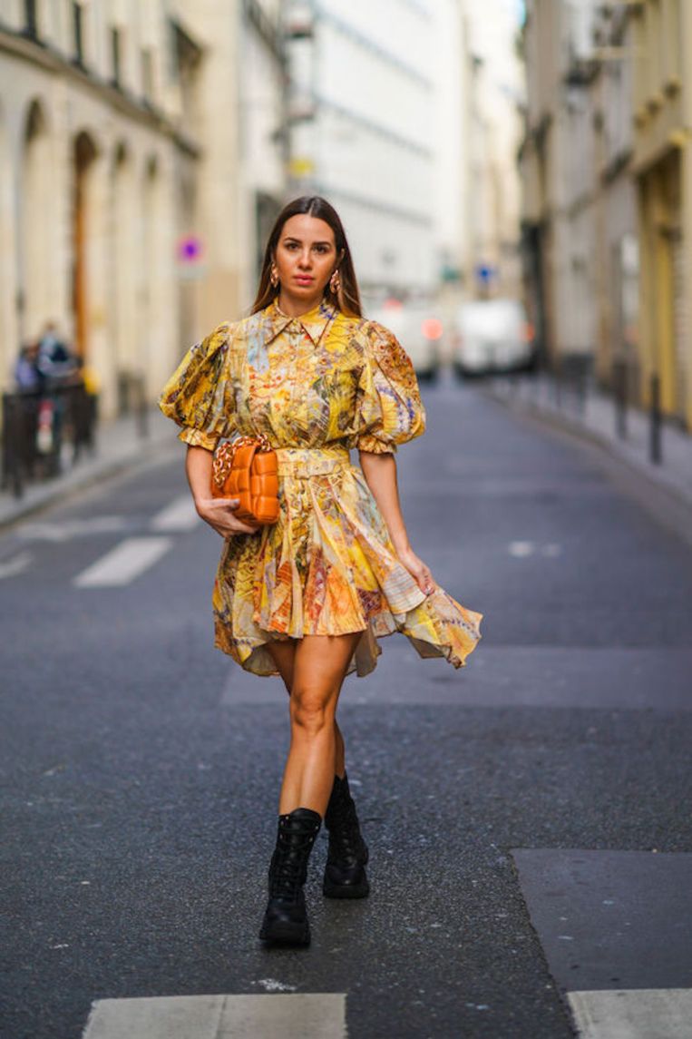 PARIS, FRANCE - NOVEMBER 21: Maria Rosaria Rizzo wears golden earrings, a yellow short flowing ruffled dress / shirt with puff sleeves and floral print from Leo&Lin, an orange/brown woven leather bag with a golden chain from Bottega Veneta, black leather boots from Prada, on November 21, 2020 in Paris, France. (Photo by Edward Berthelot/Getty Images) Beeld Getty Images