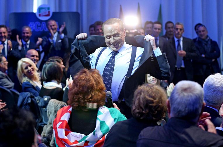 Silvio Berlusconi  doet zijn jas uit om zijn borstspieren te laten zien.   Beeld EPA