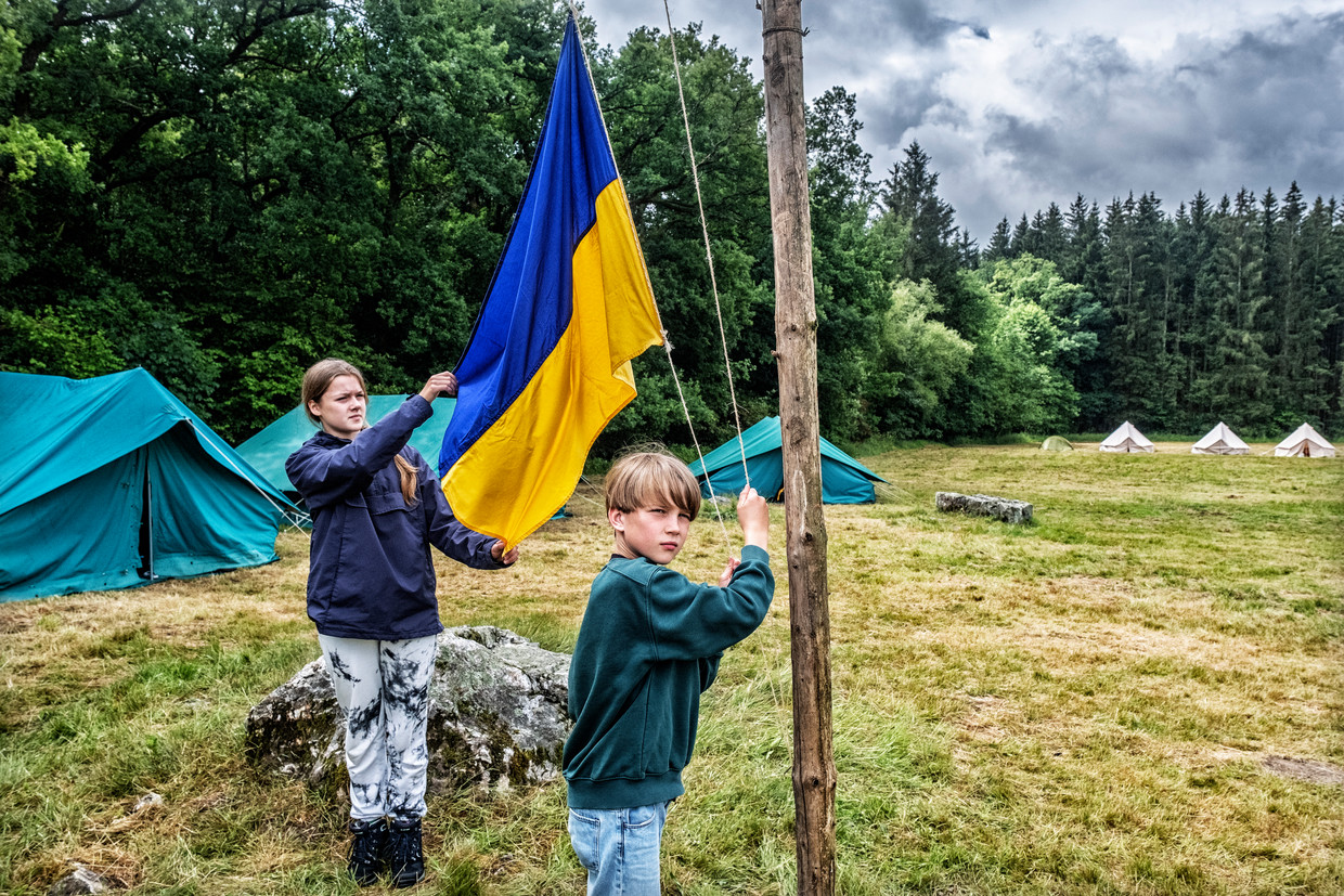Een vast ritueel: elke ochtend wordt de vlag gehesen op het scoutskamp voor Oekraïense jongeren. Beeld Tim Dirven